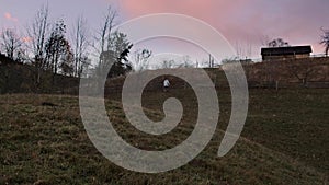 A young man rises and walks against the backdrop of mountains and villages in the spring evening. Authentic look of a