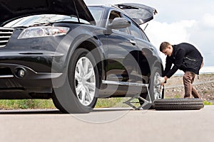 Young man with a roadside puncture