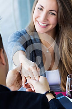 Young man romantically proposing to girlfriend