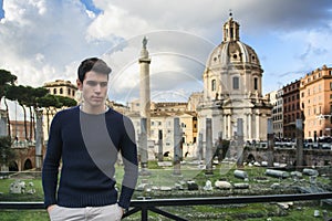 Young man in Rome standing in front of Foro Traiano and Fori Imperiali