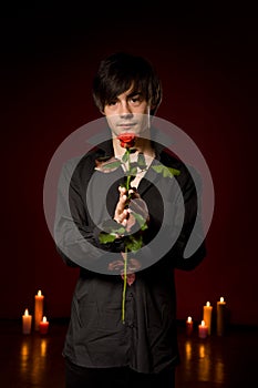 Young man with rose in black shirt