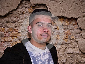 Young man on a ruined wall background