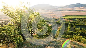 Young man runing up to hill in Czech central mountain valley at sunrise. Outdoor landscape