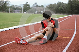 Young man runner has a knee injury. caused by falling, cramping on athletics track