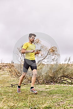 Young man running across the field in a Spartan race