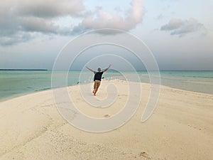 A young man is running along the beach