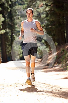 Young man running along country lane