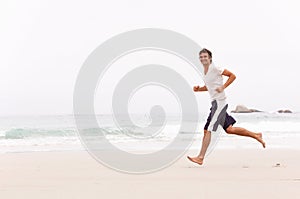 Young Man Running Along Winter Beach