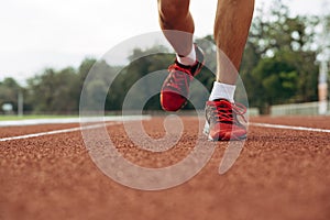 Young man running in athletics track to healthy