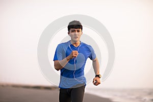 Young Man running on  beach at sunset