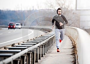 A young man running on the bridge