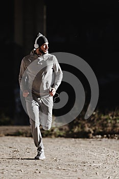 A young man running on the bridge along a river.