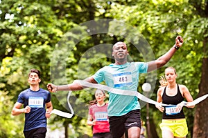 Young man running in the crowd crossing the finish line.