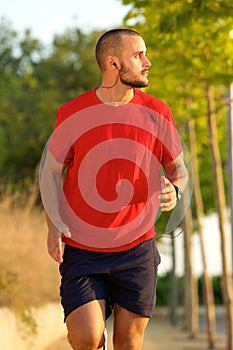 Young man running with earphones outside