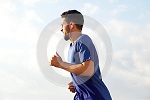 Young man running outside with earphones
