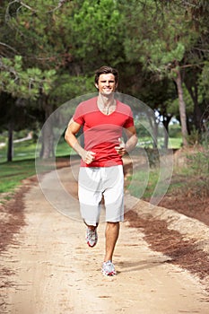 Young man running through park