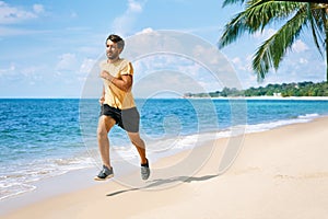 Young man running on the sea shore of tropical beach