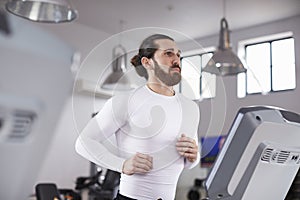 Young Man Running On Treadmill In Gym