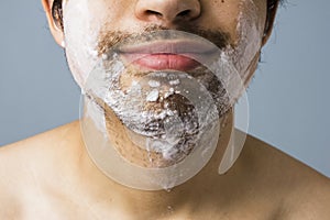 Young man's chin covered in shaving foam