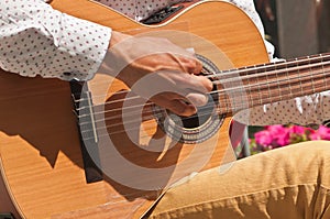 Young man`s hand strumming a guitar in Madrid, Spain