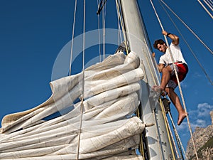 Young man on sailing ship, active lifestyle, summer sport concept