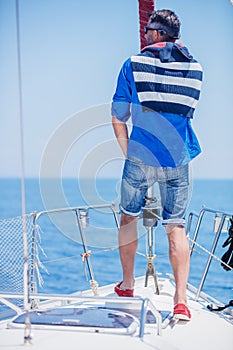 Young man sailing yacht. Holidays, people, travel