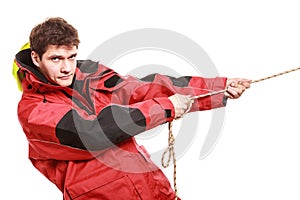 Young man sailor in red wind jacket. Sailing.