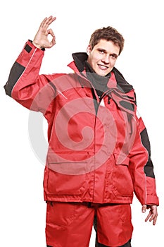 Young man sailor in red wind jacket. Sailing.