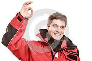 Young man sailor in red wind jacket. Sailing.