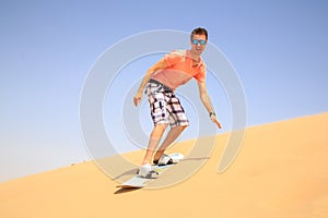 Young man sand boarding
