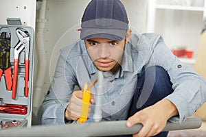 young man saws pipe wrap