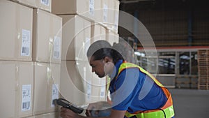 Young man scanning barcode to package box with transportation and distribution in the warehouse at factory.