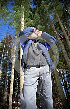 Young man scanning the forest