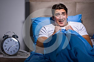 Young man scared in bed