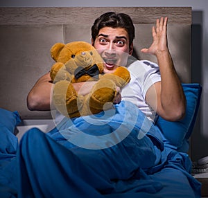 Young man scared in bed