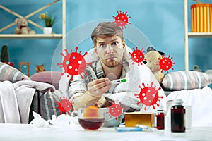 Young man scared of coronavirus spreading and worldwide cases, feeling ill, sick, fever