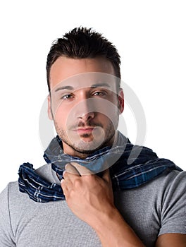 Young man with scarf, holding his neck because of throat ache