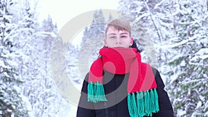 young man in a scarf on the street in winter looking at the camera 4k