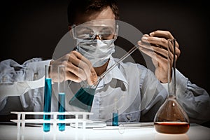 Young man scientist using auto-pipette with flask in medical science laboratory. Researcher concept.