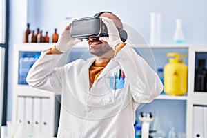Young man scientist using virtual reality goggles at laboratory