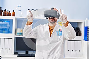 Young man scientist using virtual reality goggles at laboratory