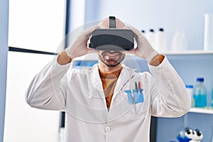 Young man scientist using virtual reality goggles at laboratory