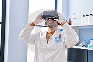 Young man scientist using virtual reality goggles at laboratory