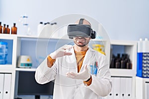 Young man scientist using virtual reality goggles at laboratory