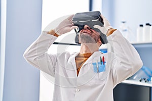 Young man scientist using virtual reality goggles at laboratory