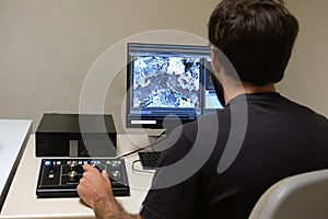 Young man scientist working with scanning electron microscope