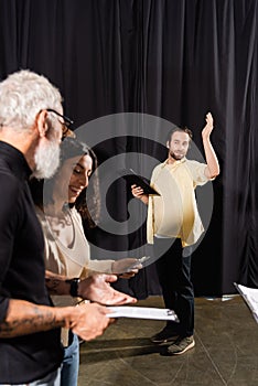 young man with screenplay gesturing during photo