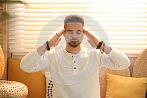 Young man during self-healing session in room