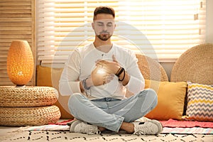 Young man during self-healing session in room