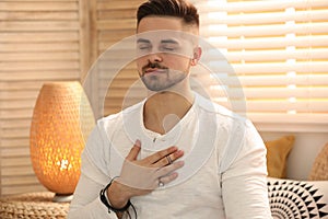 Young man during self-healing session in room